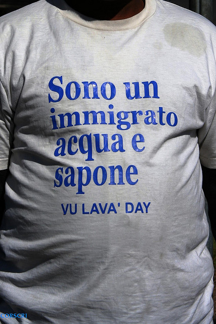 Тениска на имигрант с надпис 'Аз съм имигрант, използващ сапун и вода' за да избегна насилие. От Кристиано Корсини, Flickr (CC BY-NC-SA 2.0).